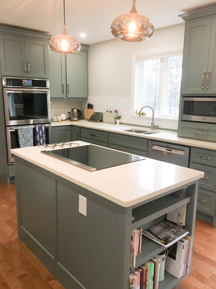 Enclosed kitchen - mid-sized transitional l-shaped medium tone wood floor and brown floor enclosed kitchen idea with a double-bowl sink, shaker cabinets, gray cabinets, quartz countertops, white backsplash, porcelain backsplash, stainless steel appliances, an island and white countertops
