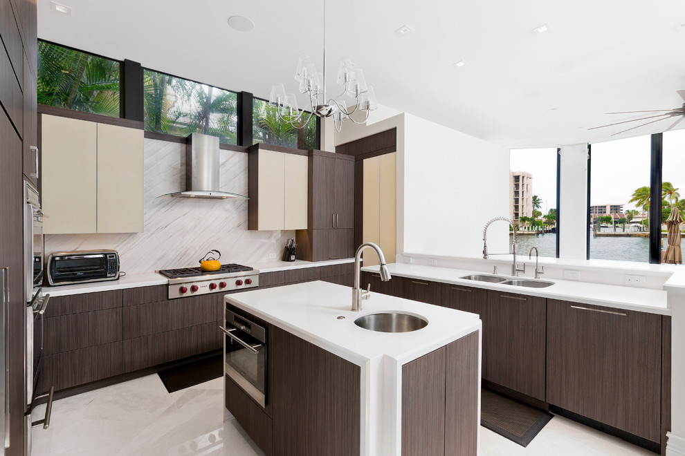 Inspiration for a contemporary u-shaped kitchen in Miami with an undermount sink, flat-panel cabinets, dark wood cabinets, white splashback, stone slab splashback, stainless steel appliances and with island.