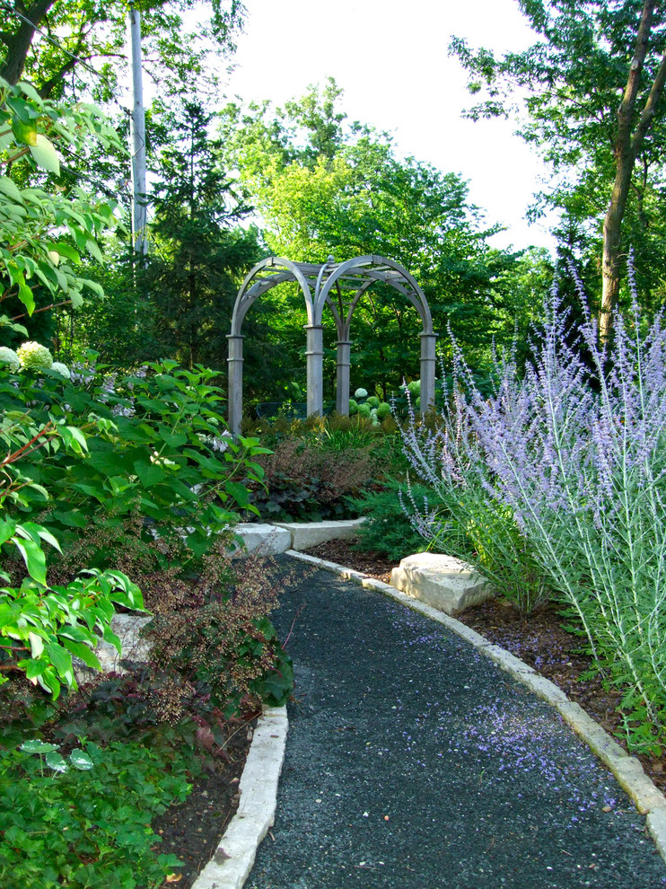 This is an example of a traditional backyard partial sun garden in Chicago with a garden path and gravel.