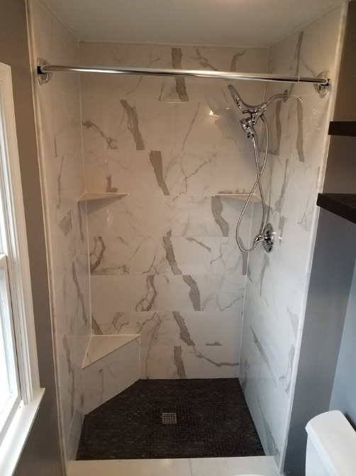 Alcove shower - mid-sized transitional white tile and marble tile porcelain tile and beige floor alcove shower idea with raised-panel cabinets, white cabinets, a two-piece toilet, beige walls, an undermount sink, quartz countertops and white countertops