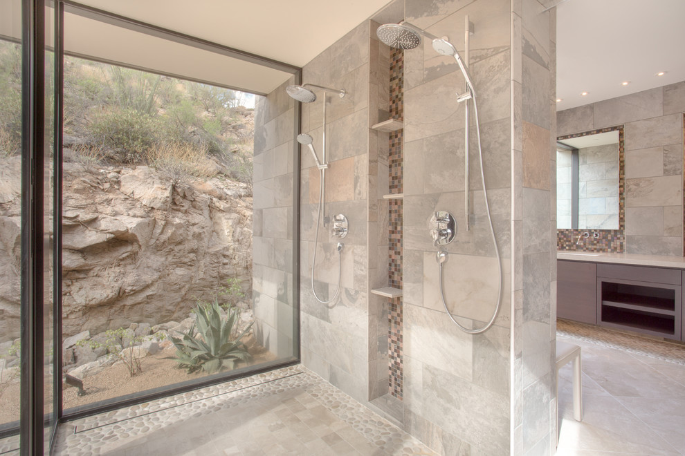 Photo of a large contemporary master bathroom in Phoenix with flat-panel cabinets, gray tile, stone tile, beige walls, limestone floors, engineered quartz benchtops, a curbless shower and grey cabinets.