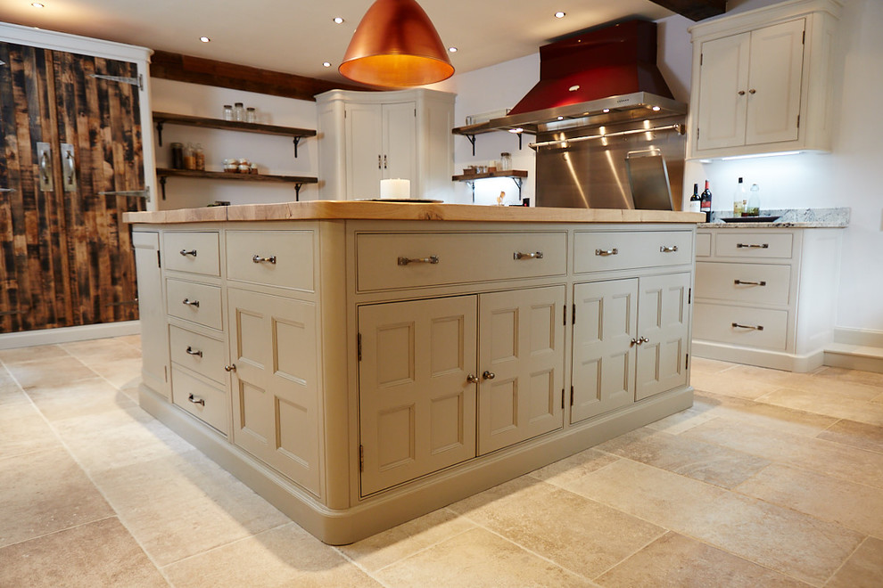 This is an example of a large traditional l-shaped eat-in kitchen in Other with an undermount sink, beaded inset cabinets, beige cabinets, wood benchtops, grey splashback, metal splashback, coloured appliances, ceramic floors, with island and beige floor.