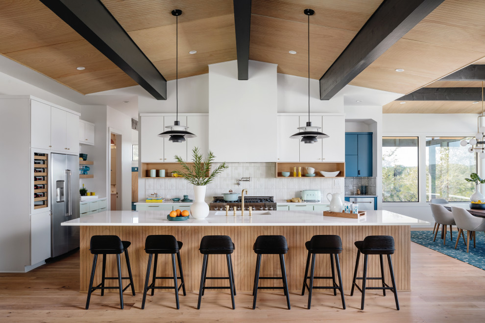 Design ideas for an expansive midcentury eat-in kitchen in Austin with a drop-in sink, flat-panel cabinets, turquoise cabinets, quartz benchtops, white splashback, porcelain splashback, stainless steel appliances, medium hardwood floors, with island, beige floor, white benchtop and wood.
