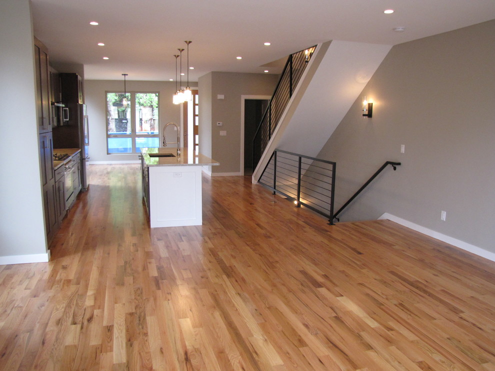 Inspiration for a mid-sized transitional medium tone wood floor open concept kitchen remodel in Denver with an undermount sink, shaker cabinets, dark wood cabinets, granite countertops, gray backsplash, glass tile backsplash, stainless steel appliances and an island