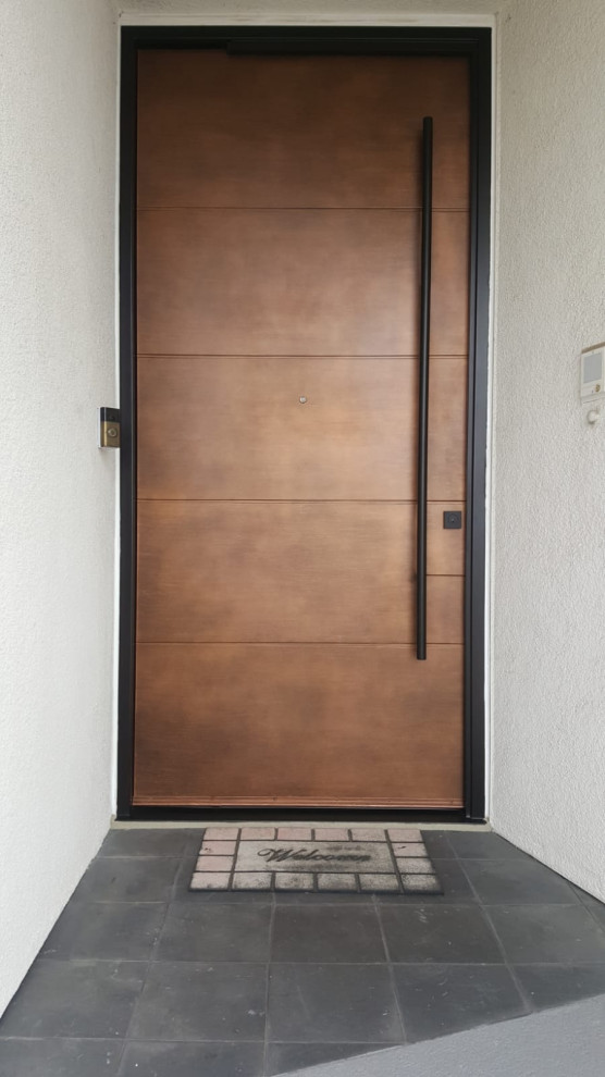 Стильный дизайн: входная дверь среднего размера в стиле модернизм с белыми стенами, поворотной входной дверью, коричневой входной дверью и серым полом - последний тренд