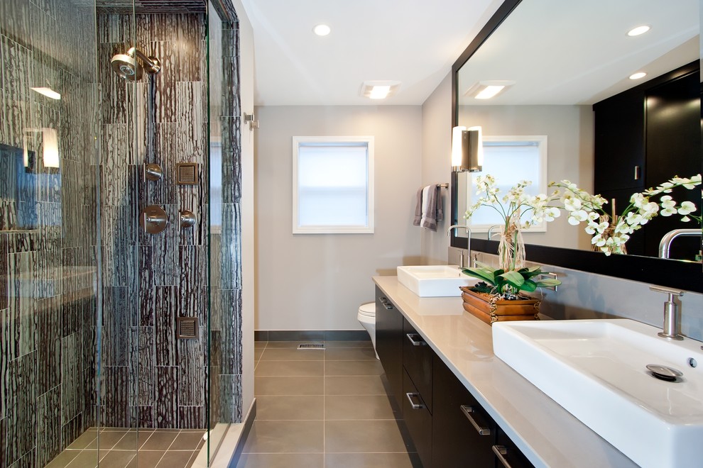 Inspiration for a mid-sized modern master bathroom in Chicago with a vessel sink, flat-panel cabinets, dark wood cabinets, an alcove shower, engineered quartz benchtops, stone tile, grey walls, porcelain floors, brown tile and beige floor.