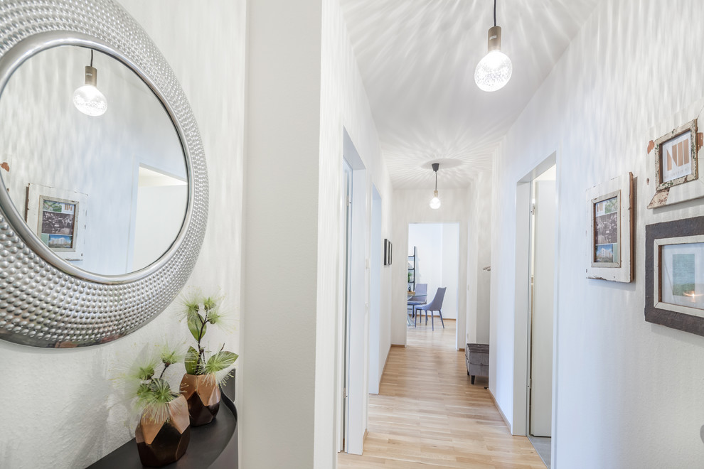 This is an example of a small contemporary hallway in Hanover with white walls, laminate floors and brown floor.
