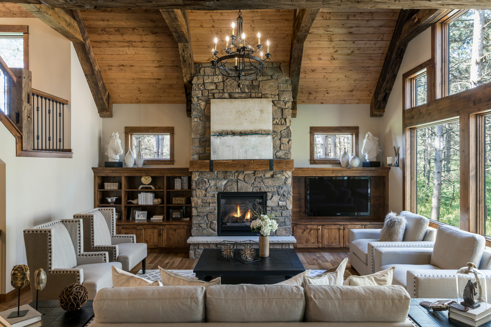 Inspiration for a country open concept family room in Other with white walls, a built-in media wall, medium hardwood floors, a standard fireplace, a stone fireplace surround and a library.