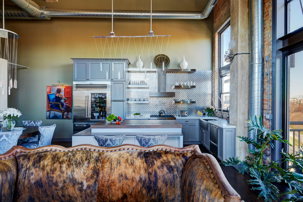Eat-in kitchen - mid-sized transitional l-shaped dark wood floor and brown floor eat-in kitchen idea in Chicago with a farmhouse sink, flat-panel cabinets, gray cabinets, quartz countertops, metallic backsplash, metal backsplash, stainless steel appliances and an island