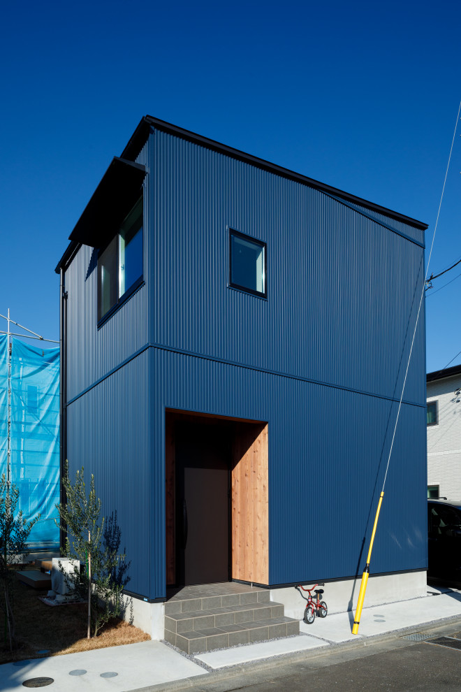 Small industrial two-storey blue house exterior in Tokyo Suburbs with metal siding, a gambrel roof and a mixed roof.