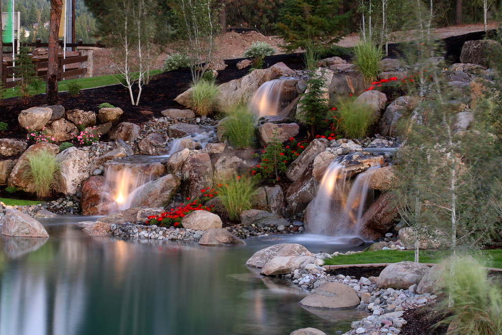 Inspiration for a large traditional backyard garden in Seattle with a water feature and natural stone pavers.