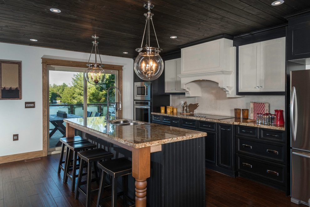 Inspiration for a mid-sized country single-wall eat-in kitchen in Toronto with an undermount sink, beaded inset cabinets, medium wood cabinets, granite benchtops, beige splashback, porcelain splashback, stainless steel appliances, medium hardwood floors and with island.