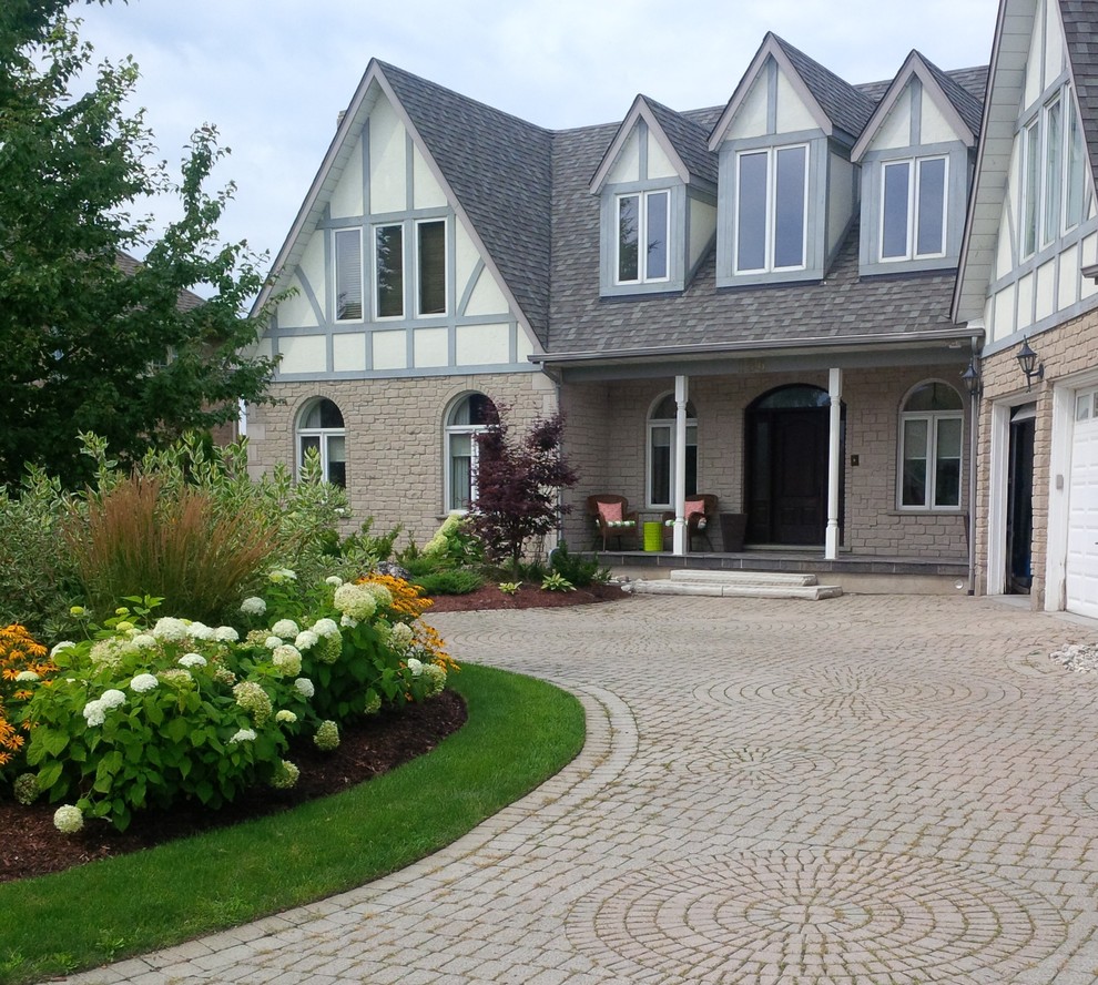 Large traditional front yard full sun driveway in Toronto with brick pavers for summer.