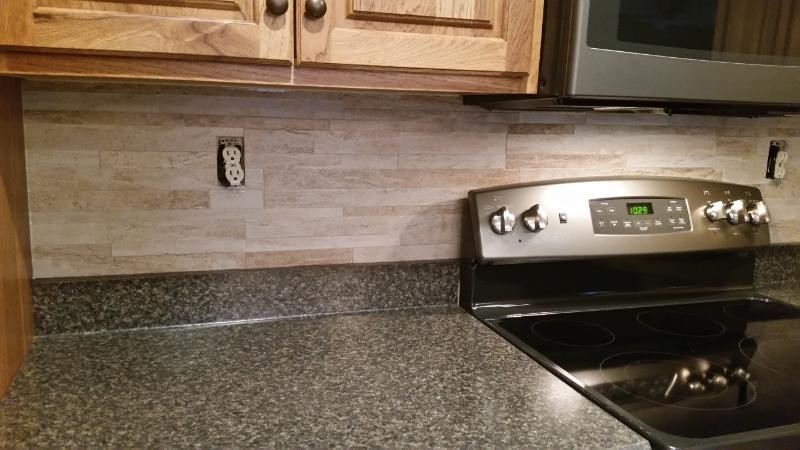 Kitchen - transitional kitchen idea in Chicago with raised-panel cabinets, medium tone wood cabinets, quartz countertops, beige backsplash, stone tile backsplash and stainless steel appliances