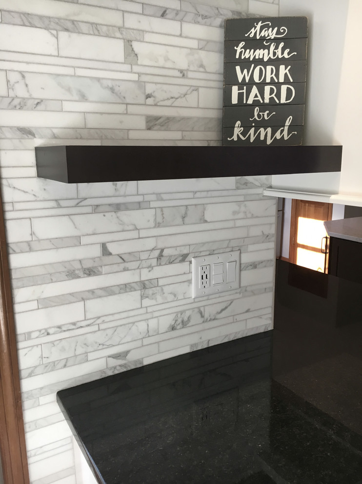 Eat-in kitchen - large transitional single-wall medium tone wood floor eat-in kitchen idea with an undermount sink, shaker cabinets, white cabinets, granite countertops, multicolored backsplash, marble backsplash, stainless steel appliances, an island and black countertops