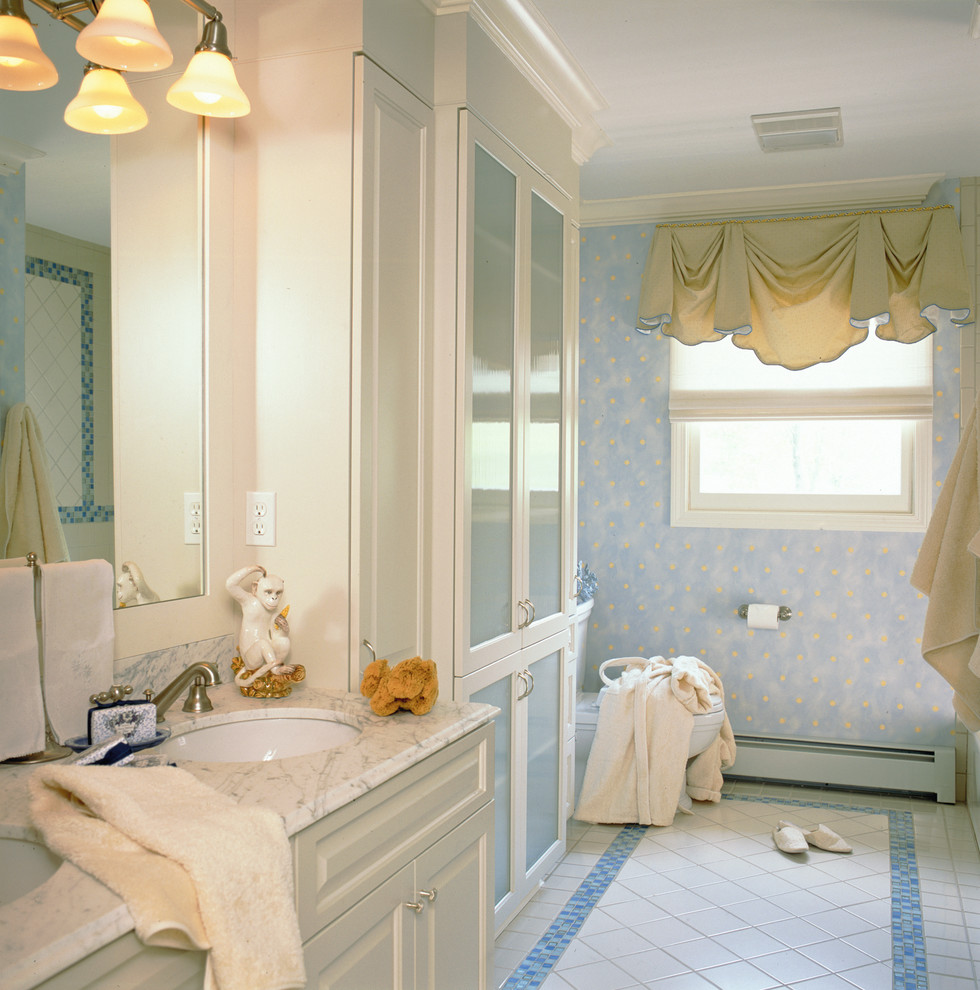 Inspiration for a mid-sized traditional master bathroom in Other with an undermount sink, recessed-panel cabinets, white cabinets, blue walls, an alcove shower, a two-piece toilet, white tile, porcelain tile, porcelain floors and marble benchtops.