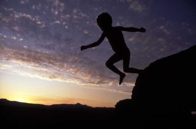 'A young bushman child leaps off a rock in Kaga Kama' by Chris Steele-Perkins