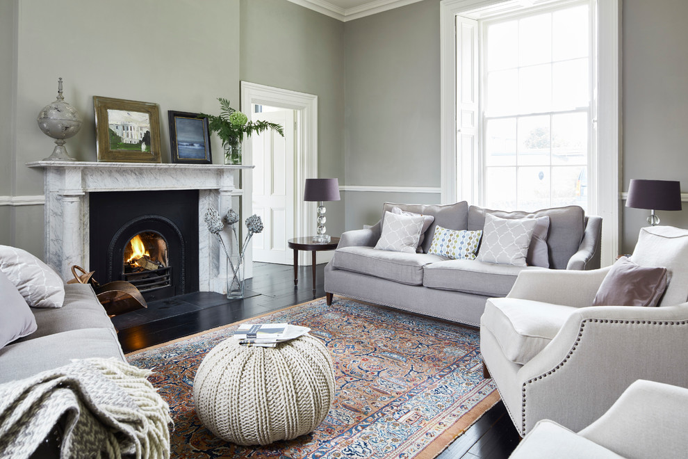 Mid-sized traditional formal living room in Dublin with grey walls, a standard fireplace, a metal fireplace surround and black floor.
