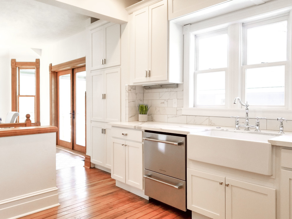 Design ideas for a small traditional l-shaped eat-in kitchen in Boise with a farmhouse sink, shaker cabinets, white cabinets, quartz benchtops, white splashback, marble splashback, stainless steel appliances, medium hardwood floors, no island, orange floor and white benchtop.