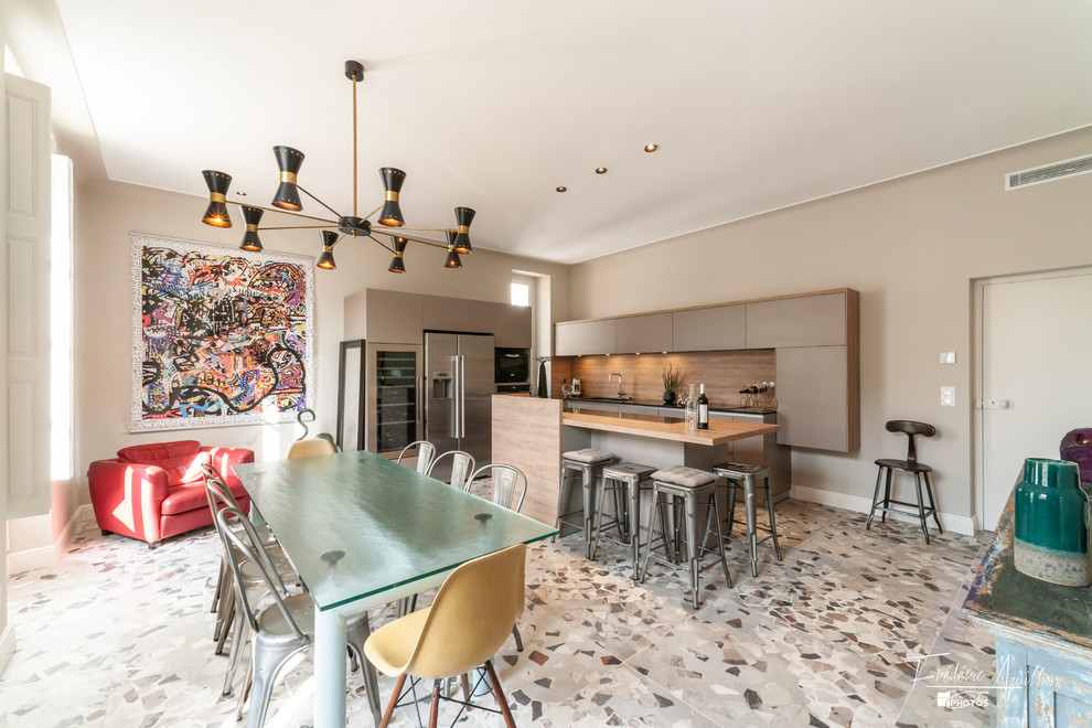 Cette image montre cuisine américaine in U With un évier encastré, un placard à porte affleurante, des portes de placard grises, un plan de travail en quartz modifié, une crédence marron, une crédence en bois, un électroménager en acier inoxydable, carreaux de ciment au sol, îlot, un sol multicolore and plan de travail noir.
