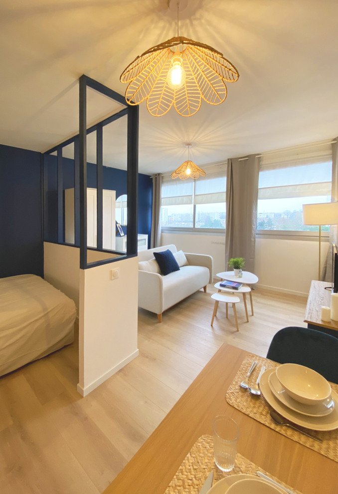 Foto de salón abierto minimalista de tamaño medio sin chimenea con paredes azules, suelo laminado, televisor independiente y suelo beige