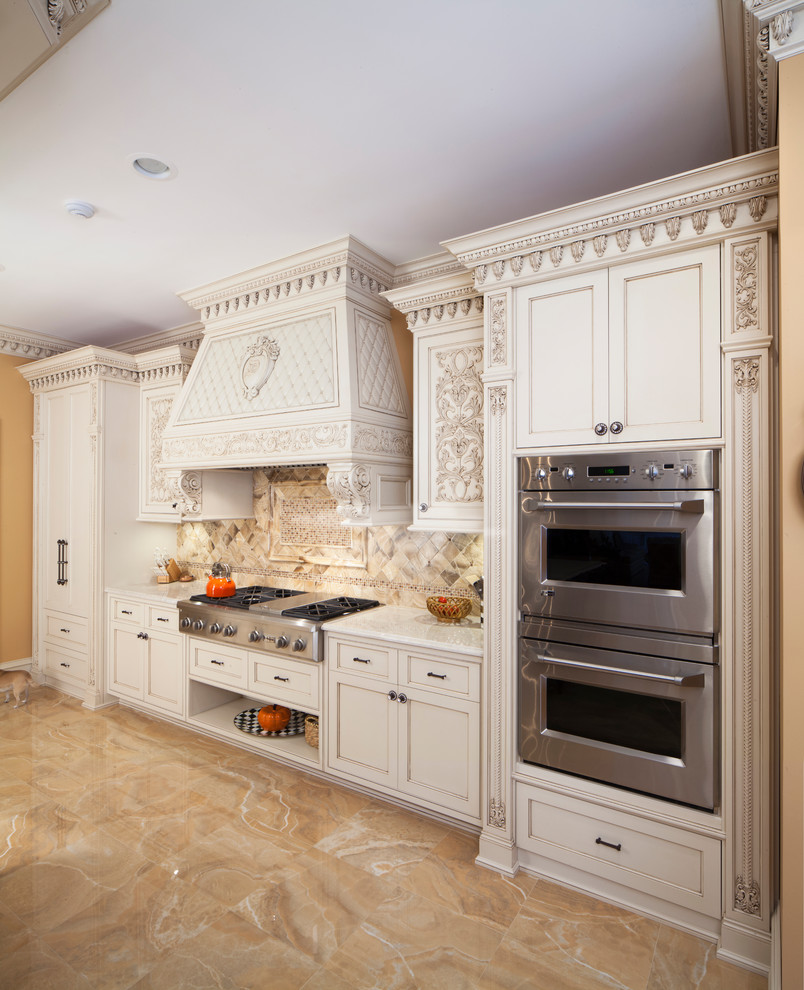 This is an example of a large traditional l-shaped eat-in kitchen in New York with an undermount sink, raised-panel cabinets, beige cabinets, granite benchtops, beige splashback, ceramic splashback, stainless steel appliances, ceramic floors and multiple islands.