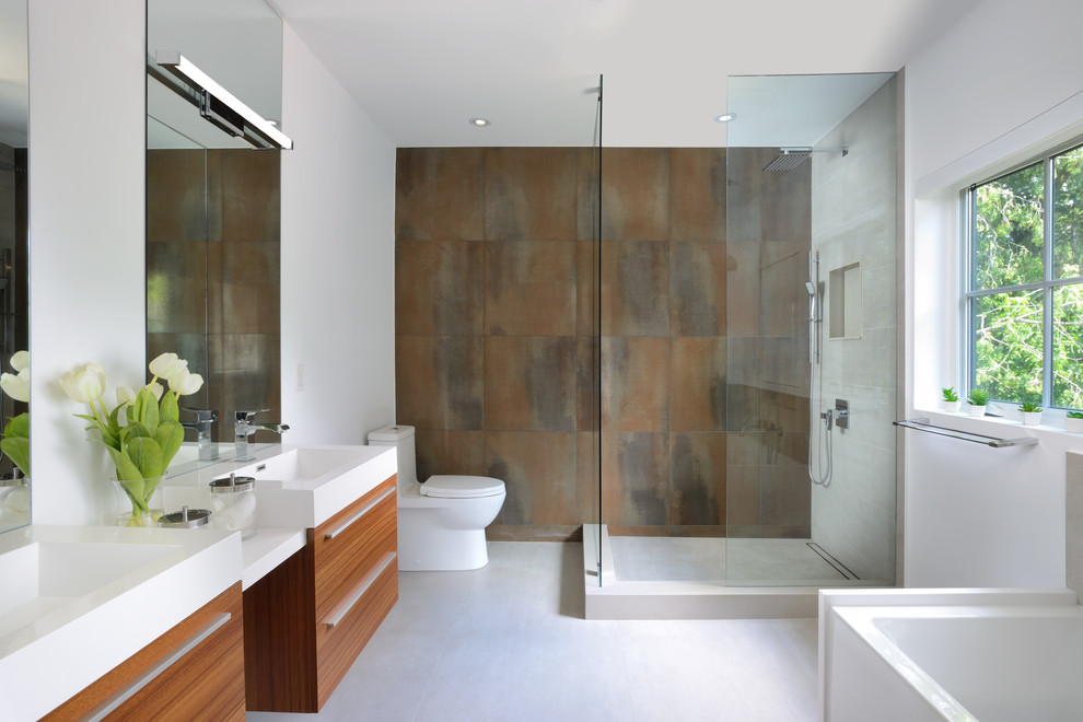 Mid-sized contemporary master bathroom in Toronto with flat-panel cabinets, medium wood cabinets, brown tile, white walls, white floor, an open shower, a freestanding tub, an alcove shower, a two-piece toilet, concrete floors and an integrated sink.