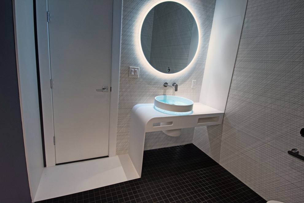 Design ideas for a small modern powder room in Charlotte with white cabinets, a bidet, black and white tile, ceramic tile, black walls, mosaic tile floors, a vessel sink, solid surface benchtops, black floor, white benchtops and a built-in vanity.