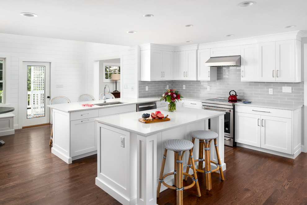 Mid-sized traditional l-shaped eat-in kitchen in Boston with an undermount sink, shaker cabinets, white cabinets, quartzite benchtops, grey splashback, subway tile splashback, stainless steel appliances, brown floor, dark hardwood floors and with island.