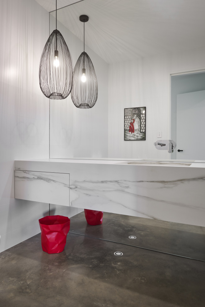 Inspiration for a large contemporary powder room in Perth with white cabinets, concrete floors, an integrated sink, tile benchtops, grey floor, white benchtops and a floating vanity.