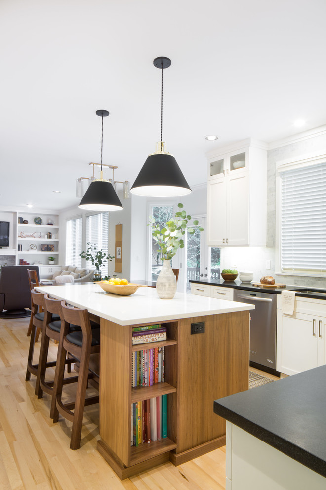 Inspiration for a mid-sized transitional l-shaped light wood floor and brown floor eat-in kitchen remodel in Seattle with an undermount sink, shaker cabinets, white cabinets, quartz countertops, multicolored backsplash, marble backsplash, stainless steel appliances and an island