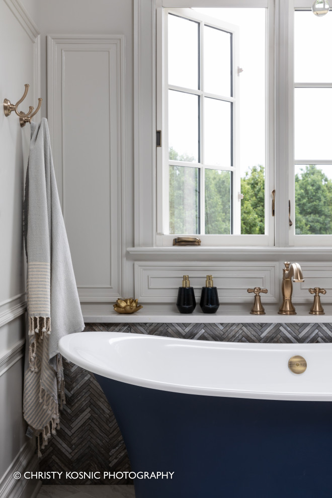 Imagen de cuarto de baño clásico grande con bañera exenta, baldosas y/o azulejos de mármol y panelado
