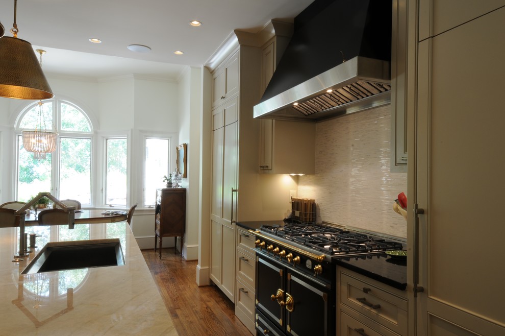 Inspiration for a large transitional u-shaped dark wood floor and brown floor open concept kitchen remodel in Birmingham with an undermount sink, shaker cabinets, white cabinets, granite countertops, white backsplash, mosaic tile backsplash, paneled appliances and an island