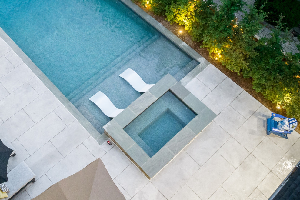 Imagen de piscina clásica renovada de tamaño medio rectangular en patio trasero con paisajismo de piscina y suelo de hormigón estampado
