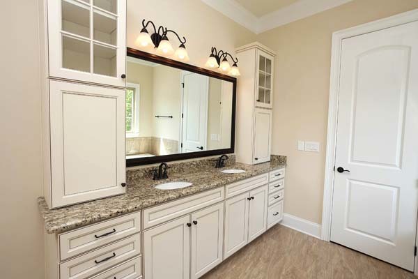 This is an example of a mid-sized traditional master bathroom in Charlotte with an undermount sink, recessed-panel cabinets, white cabinets, granite benchtops, ceramic tile, beige walls and ceramic floors.