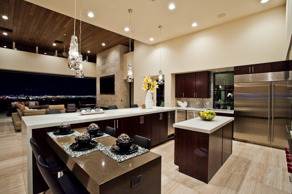 Design ideas for a mid-sized transitional l-shaped open plan kitchen in Las Vegas with flat-panel cabinets, dark wood cabinets, solid surface benchtops, stainless steel appliances, porcelain floors, beige floor, white benchtop and multiple islands.
