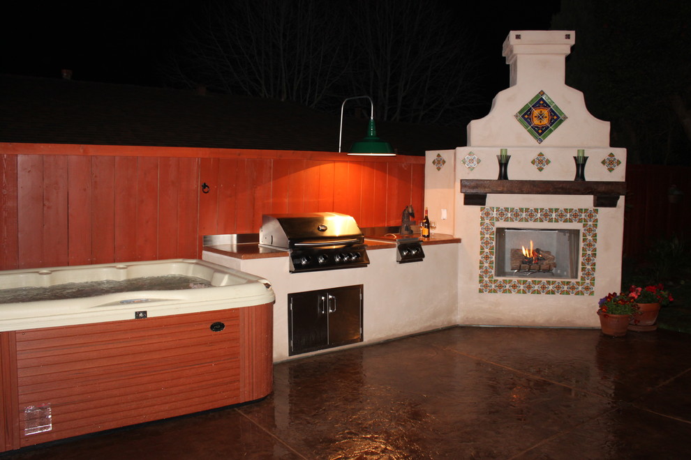 Photo of a mid-sized mediterranean side yard patio in San Diego with an outdoor kitchen, stamped concrete and no cover.