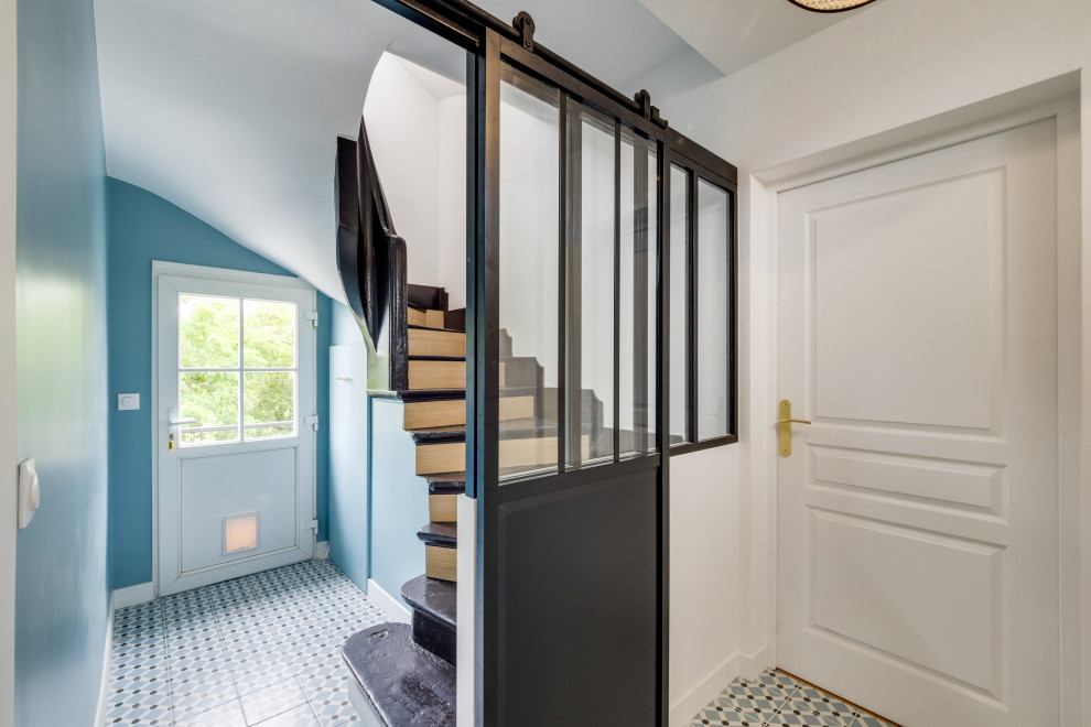 パリにあるお手頃価格の中くらいなトラディショナルスタイルのおしゃれな玄関ホール (白い壁、セラミックタイルの床、白いドア、青い床) の写真