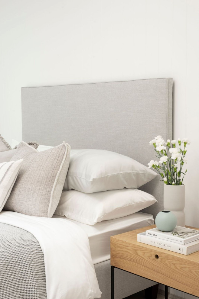 Imagen de dormitorio principal minimalista de tamaño medio con paredes blancas, suelo laminado, suelo amarillo y boiserie