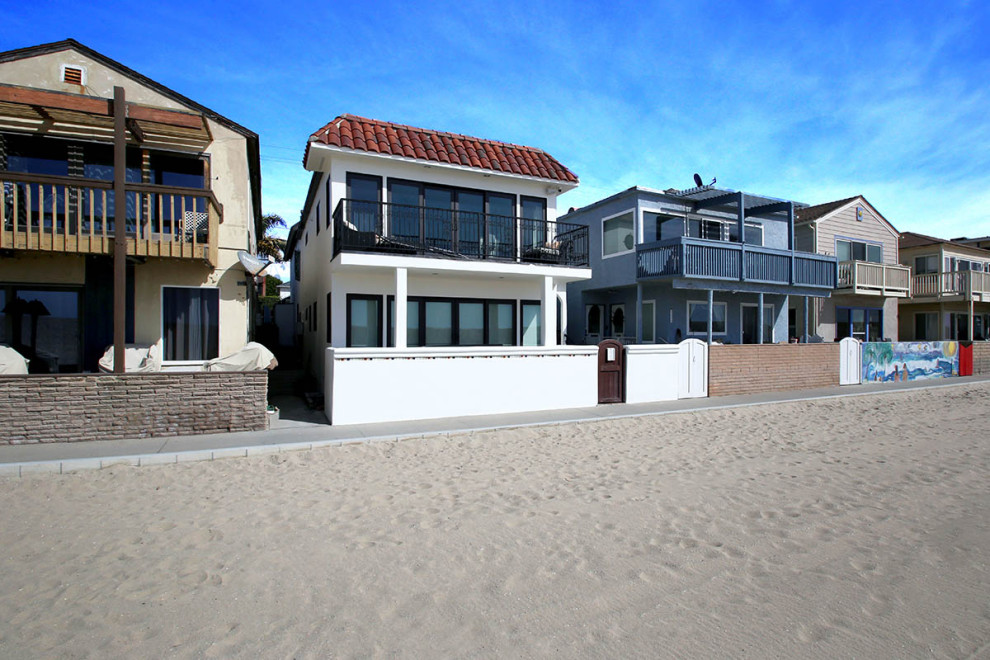 Ejemplo de fachada de casa bifamiliar blanca y roja mediterránea grande de dos plantas con revestimiento de estuco, tejado plano y tejado de teja de madera
