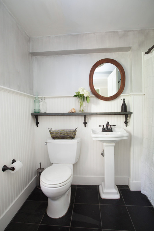 This is an example of a small traditional bathroom in New York with a pedestal sink, an alcove tub, a shower/bathtub combo, a two-piece toilet, stone tile, gray tile, grey walls and slate floors.