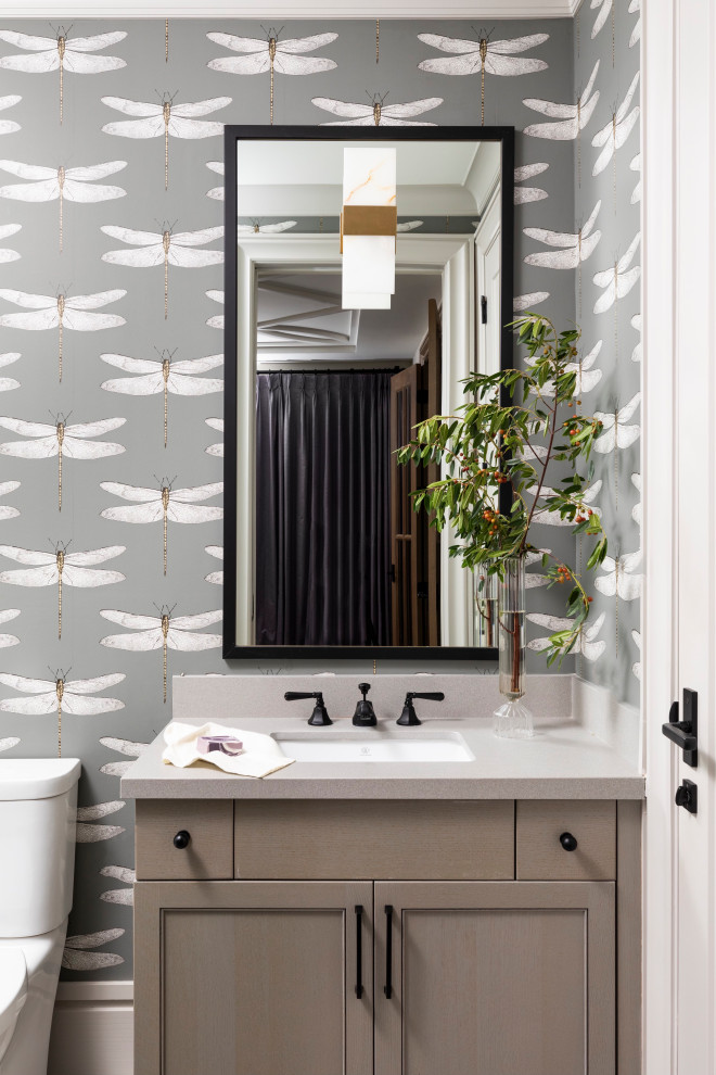 This is an example of a mid-sized modern powder room in Houston with shaker cabinets, brown cabinets, multi-coloured walls, laminate floors, black benchtops, a built-in vanity and wallpaper.
