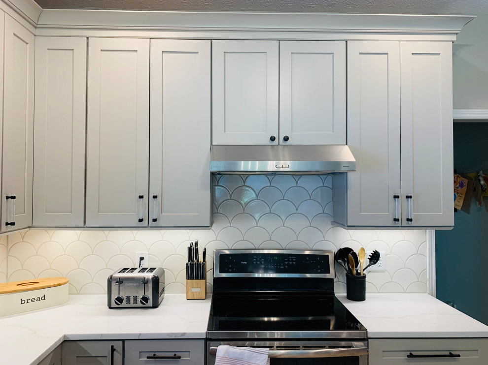 Example of a transitional kitchen design with shaker cabinets, gray cabinets, quartzite countertops, white backsplash, stainless steel appliances, white countertops and glass tile backsplash