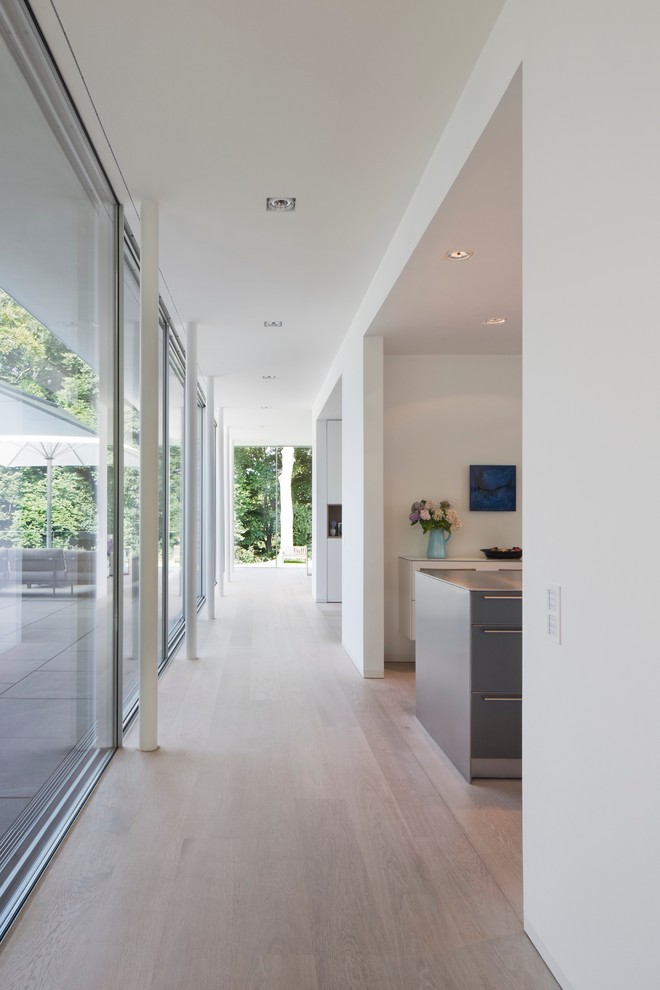 Inspiration for a large contemporary hallway in Hamburg with white walls and light hardwood floors.