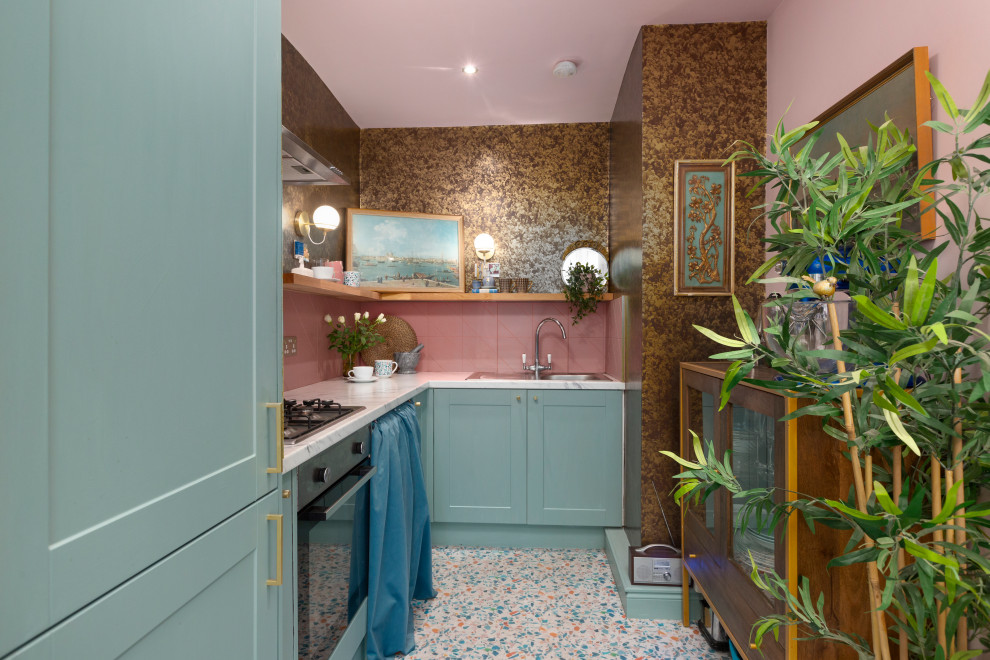 Photo of a small eclectic l-shaped separate kitchen in Edinburgh with a single-bowl sink, shaker cabinets, blue cabinets, laminate benchtops, pink splashback, ceramic splashback, stainless steel appliances, vinyl floors, no island, multi-coloured floor and grey benchtop.