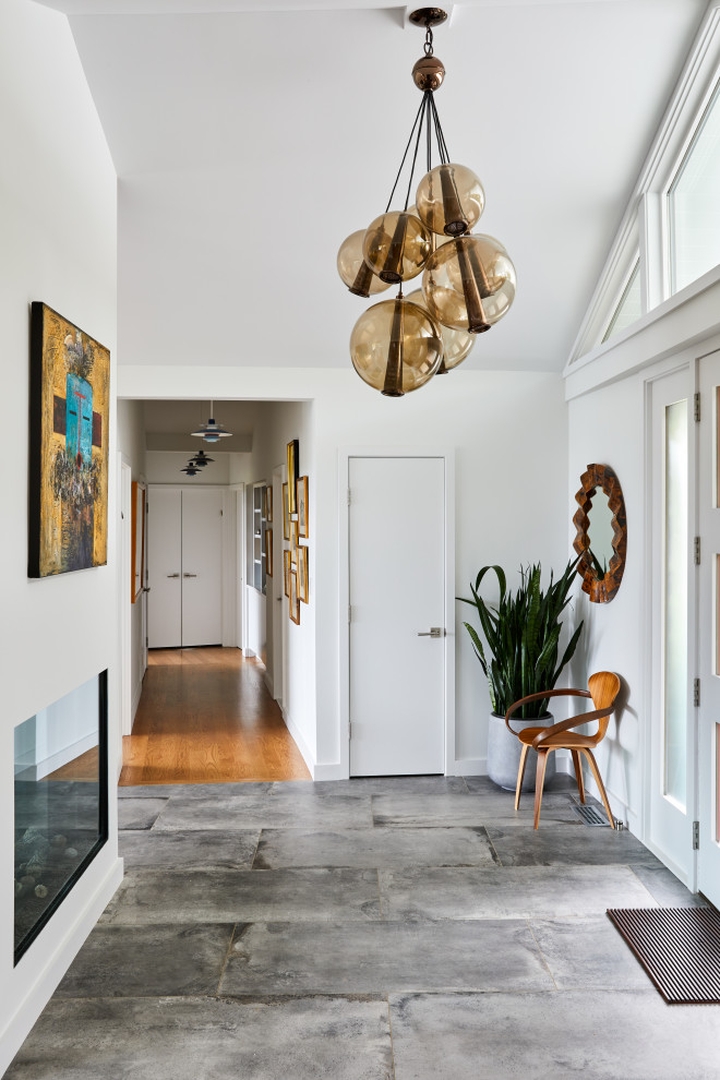 Immagine di un ingresso o corridoio minimalista con pareti bianche, pavimento grigio e soffitto a volta