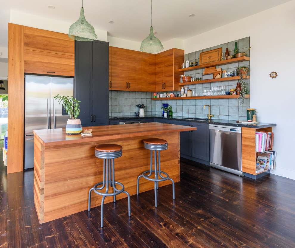 Mid-sized country l-shaped kitchen in Melbourne with a drop-in sink, flat-panel cabinets, brown cabinets, green splashback, stainless steel appliances, dark hardwood floors, multiple islands and brown floor.