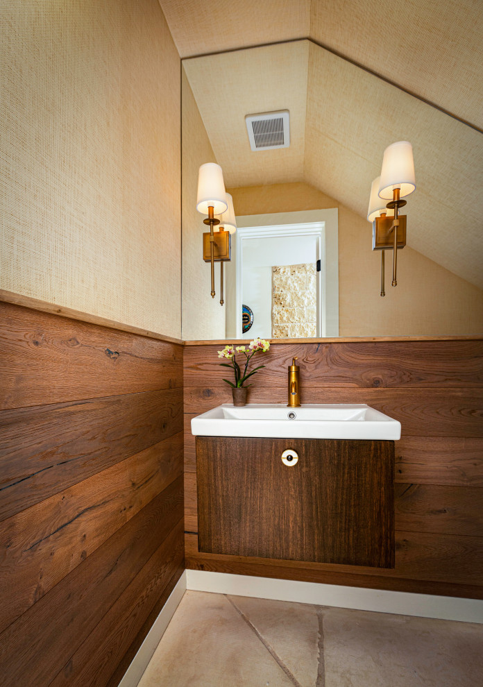 Small transitional powder room in Austin with flat-panel cabinets, a one-piece toilet, beige walls, limestone floors, beige floor, white benchtops, a floating vanity, vaulted, wallpaper, wallpaper, dark wood cabinets and a console sink.