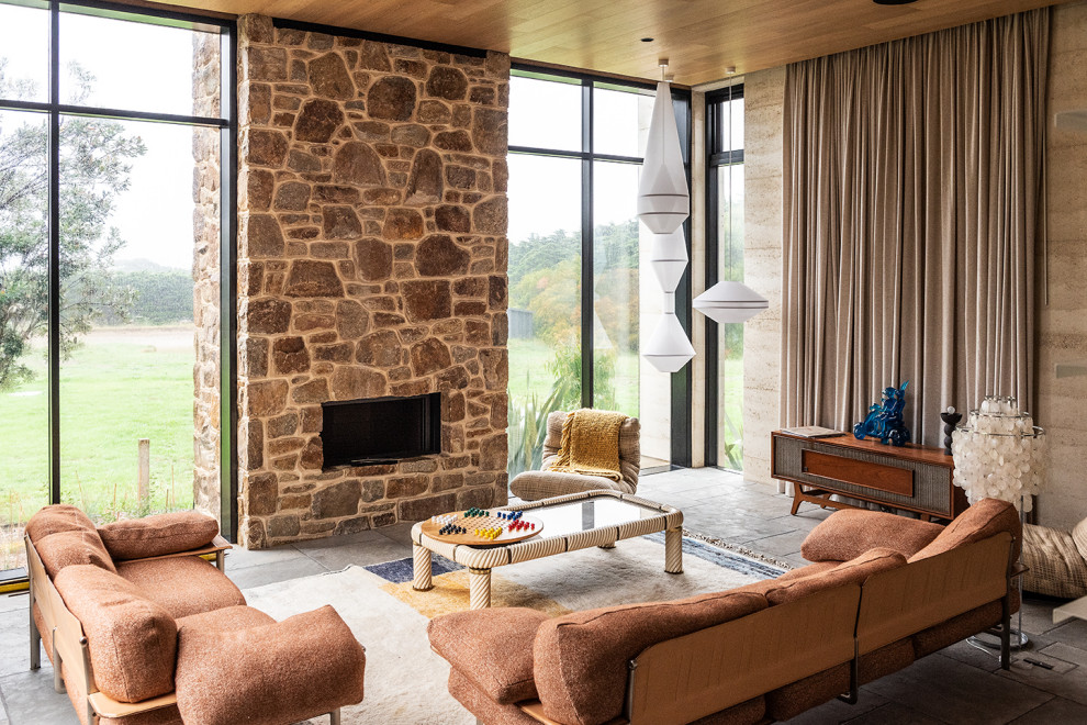 Exemple d'un grand salon tendance ouvert avec un mur beige, une cheminée standard, un manteau de cheminée en pierre, aucun téléviseur, un sol gris et un plafond en lambris de bois.