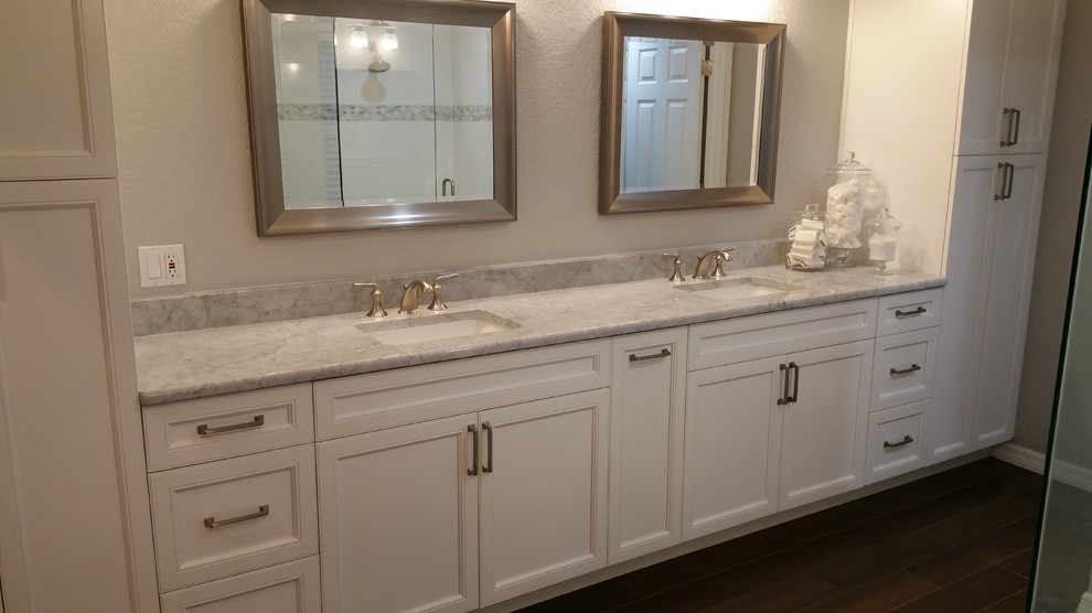 Design ideas for a large traditional master bathroom in Tampa with recessed-panel cabinets, white cabinets, a freestanding tub, a corner shower, a two-piece toilet, white tile, porcelain tile, grey walls, porcelain floors, an undermount sink and marble benchtops.